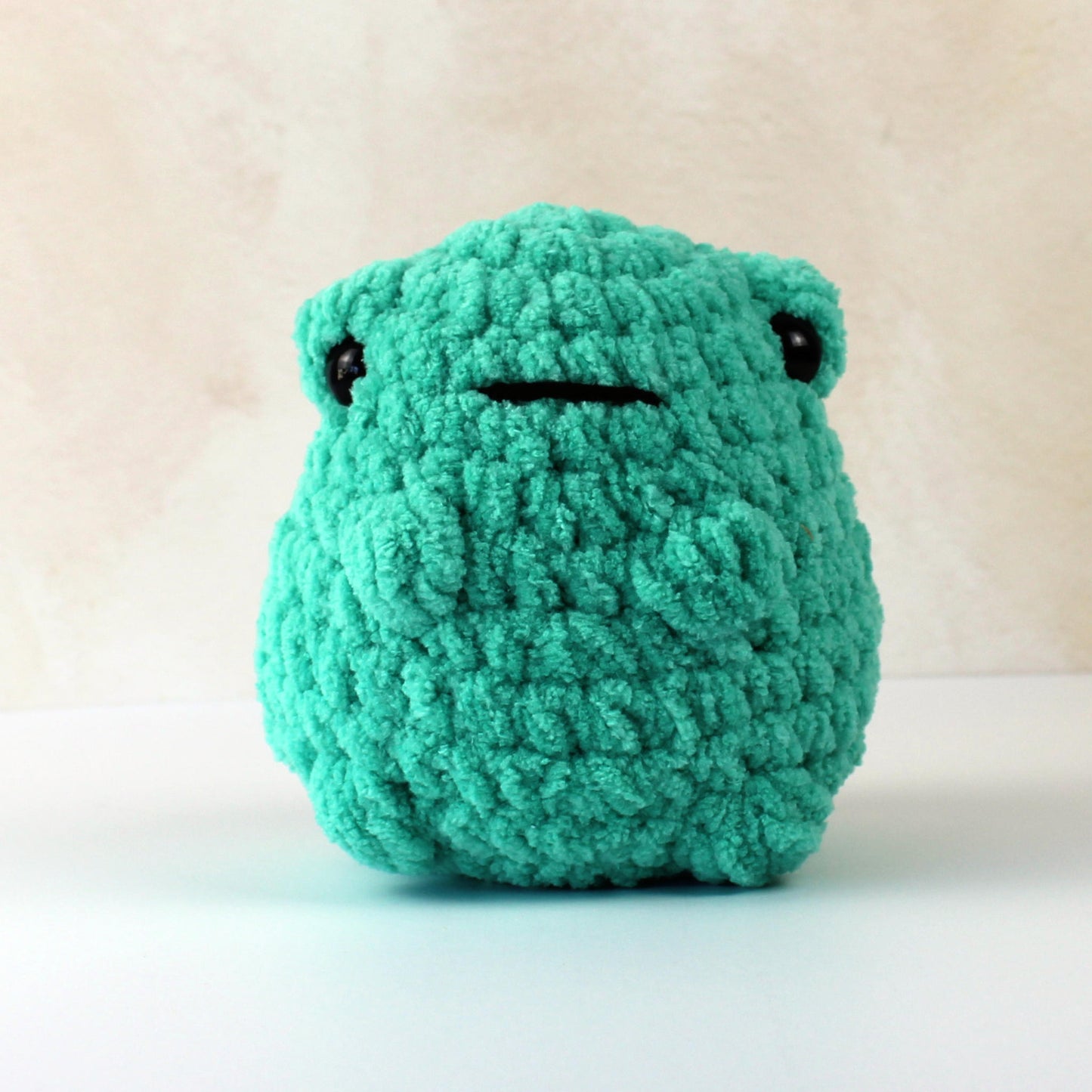 Handmade crochet frog plush toy in green blanket yarn, soft gift for kids or collectors.