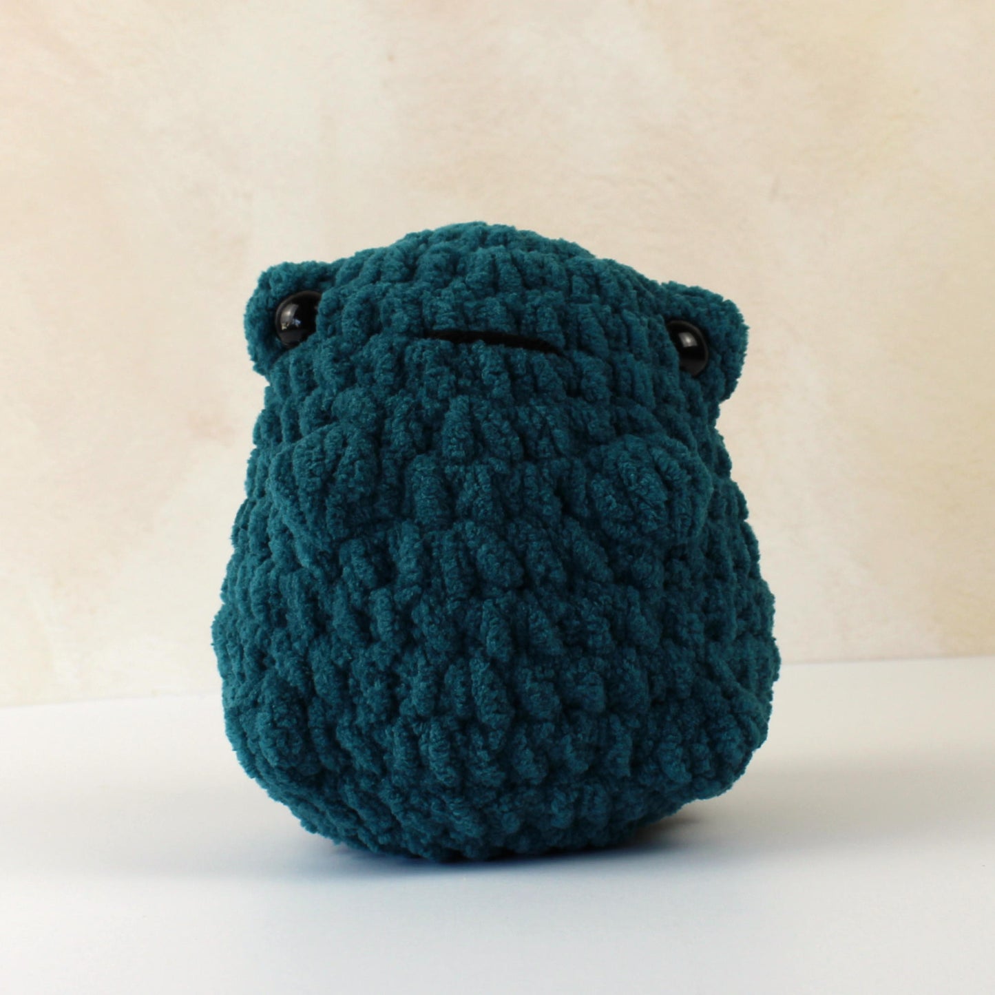 Handmade crochet frog plush toy in dark green blanket yarn, soft gift for kids or collectors.