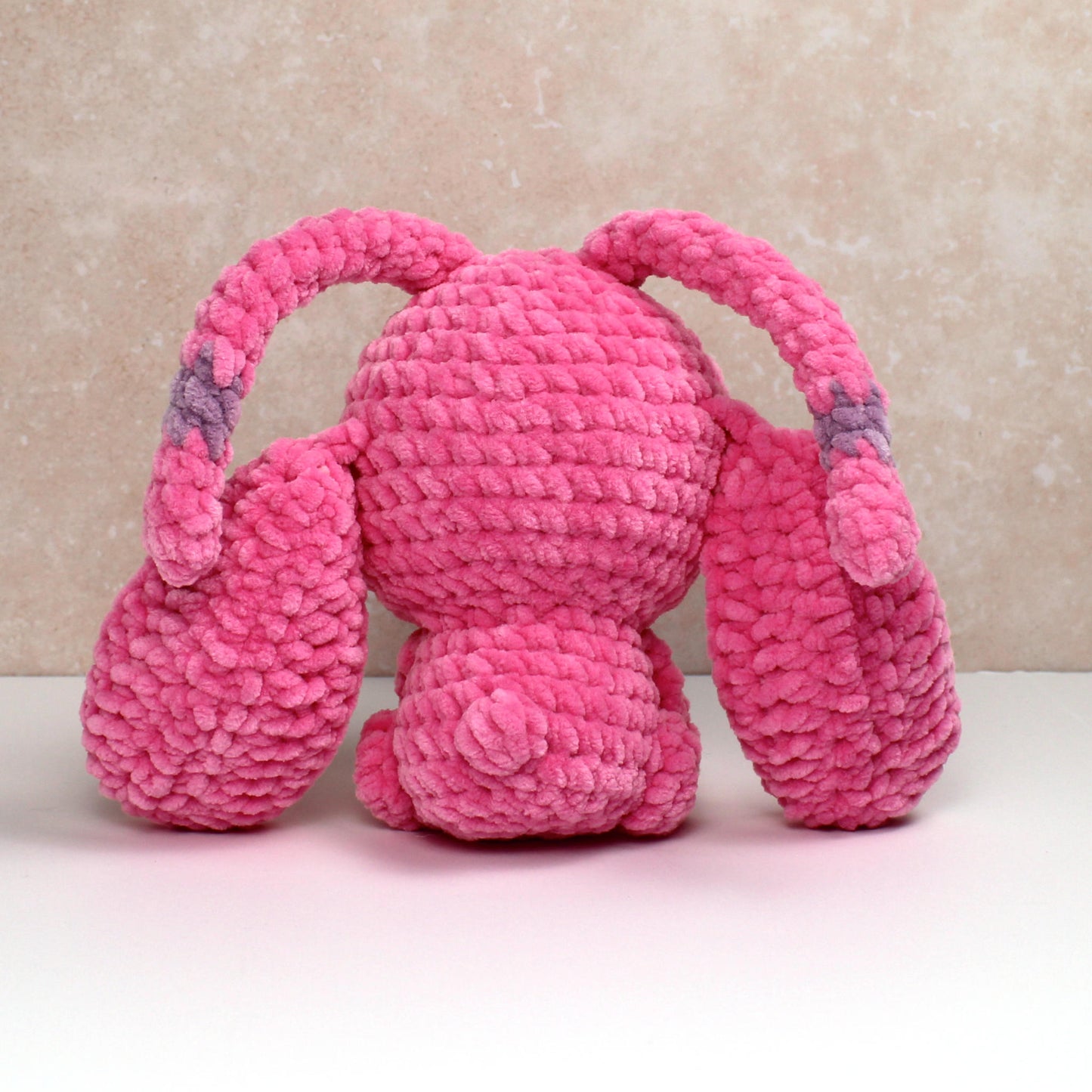 Handmade crochet plush creature in pink with long ears. Handmade toy perfect for unique gifts or collections.