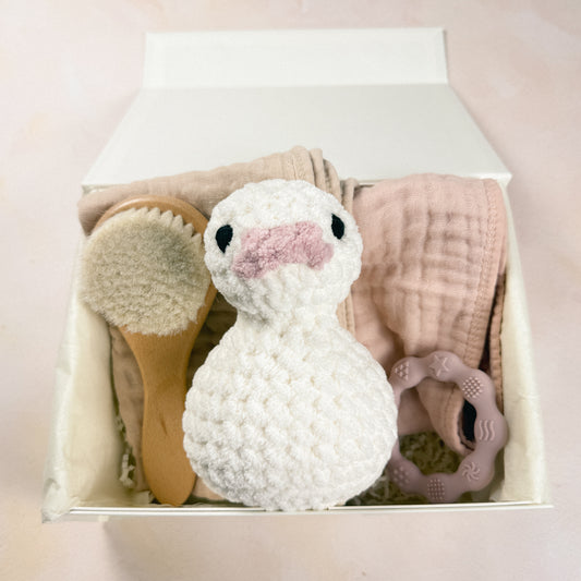 Petal & Pearl First Days Edit arranged inside a magnetic gift box with plush duck, burp cloths, baby brush, and teether.
