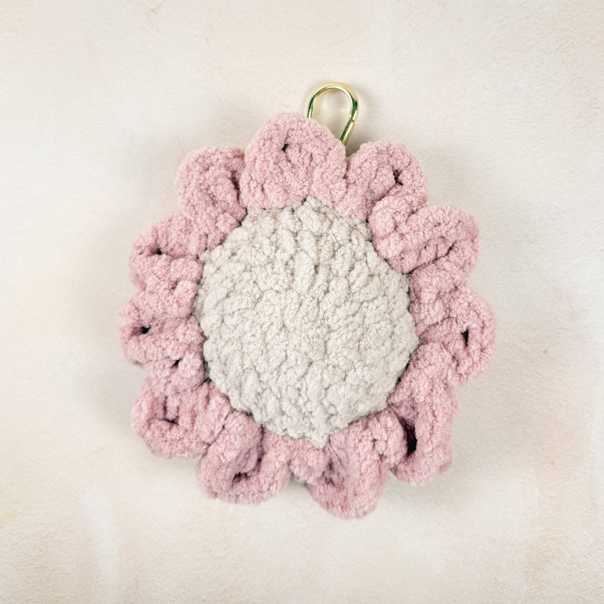 Blush daisy chain charm laid flat on a neutral background flower detail.