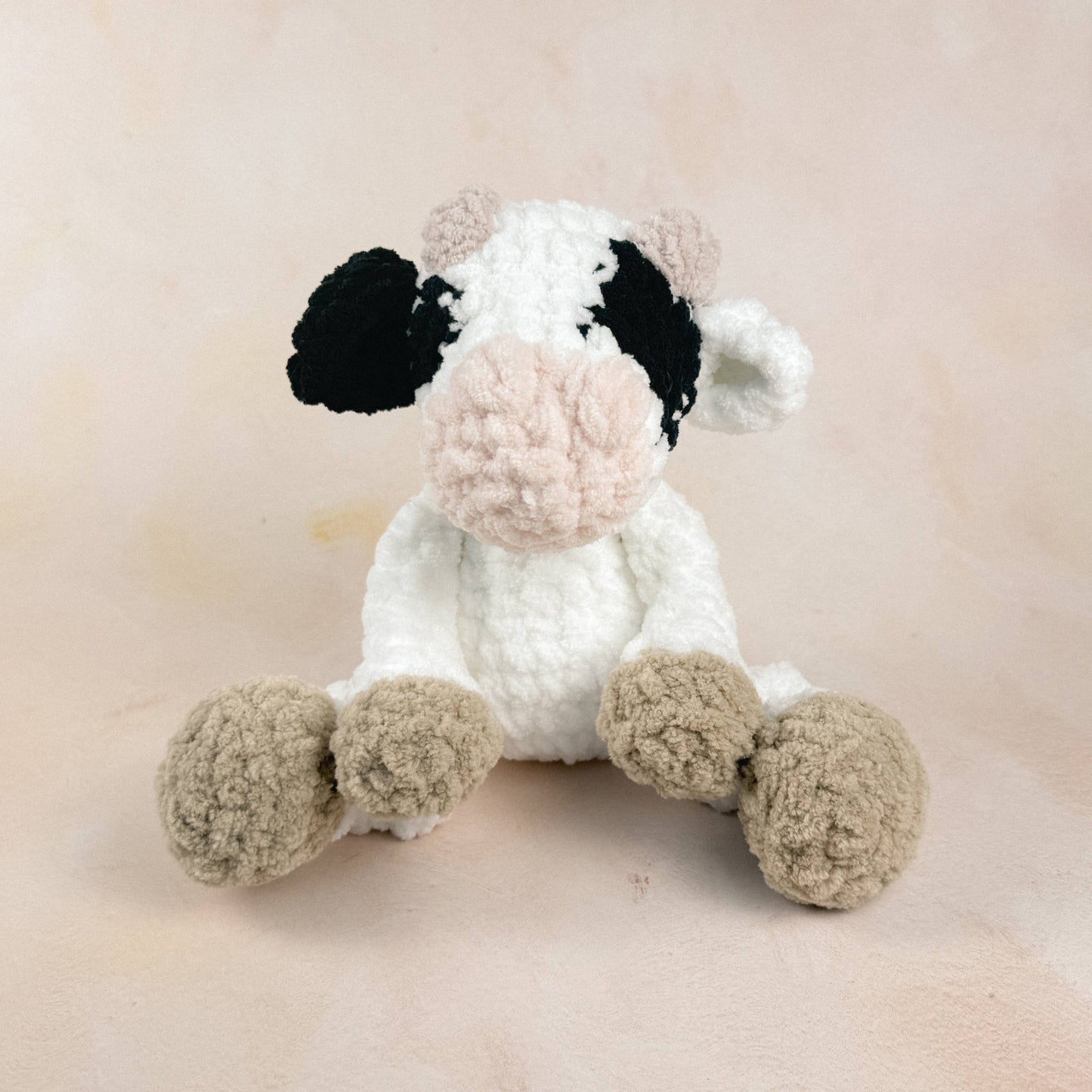 Cow plush shown on a neutral background to display size, shape, and texture.