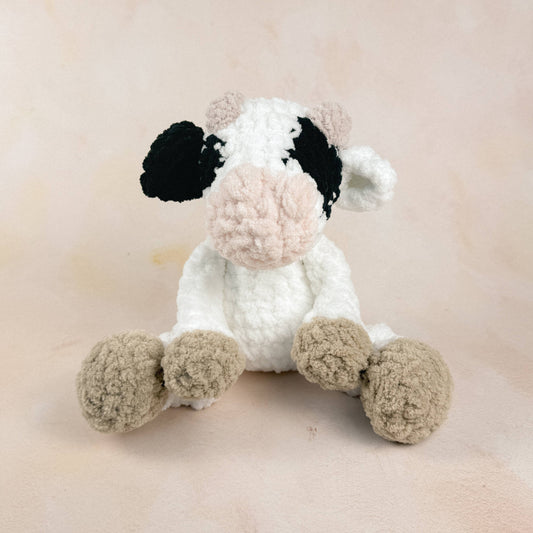 Cow plush shown on a neutral background to display size, shape, and texture.