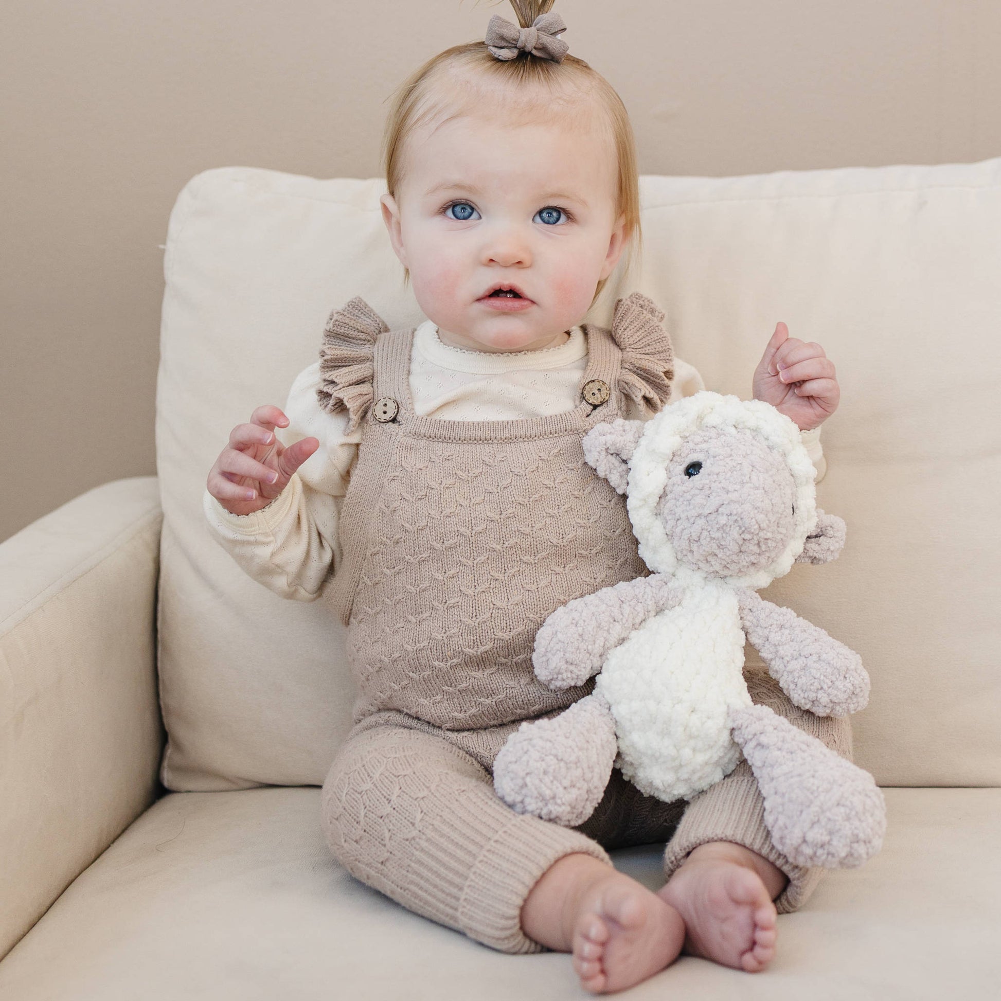Lamb lovey held by a baby to show scale and use.